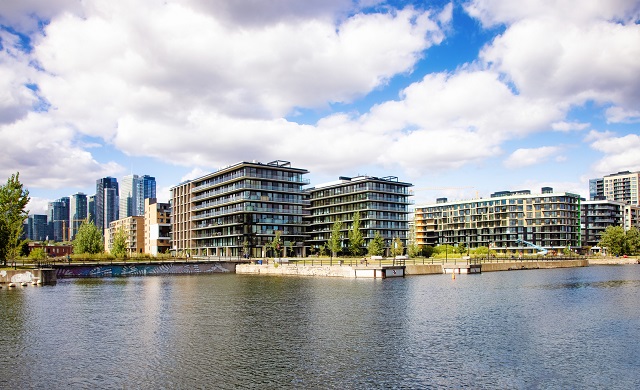 Urban condo buildings in front of a lake on a sunny day 