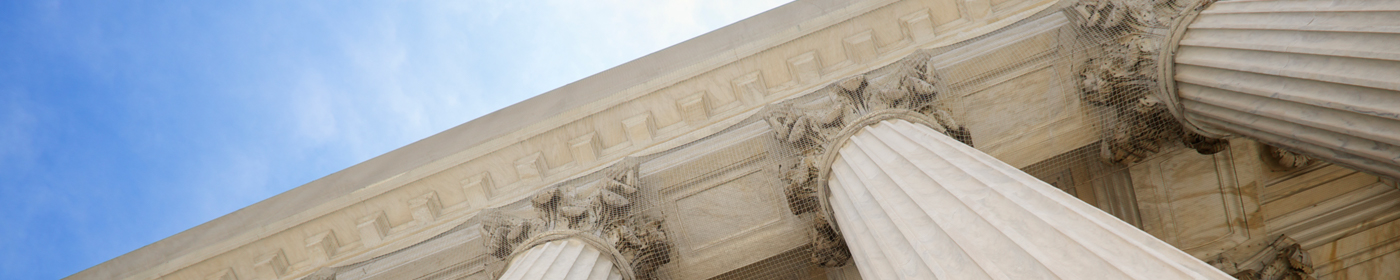 Image de bannière : Trois piliers et plafond d'un bâtiment d'architecture néoclassique.